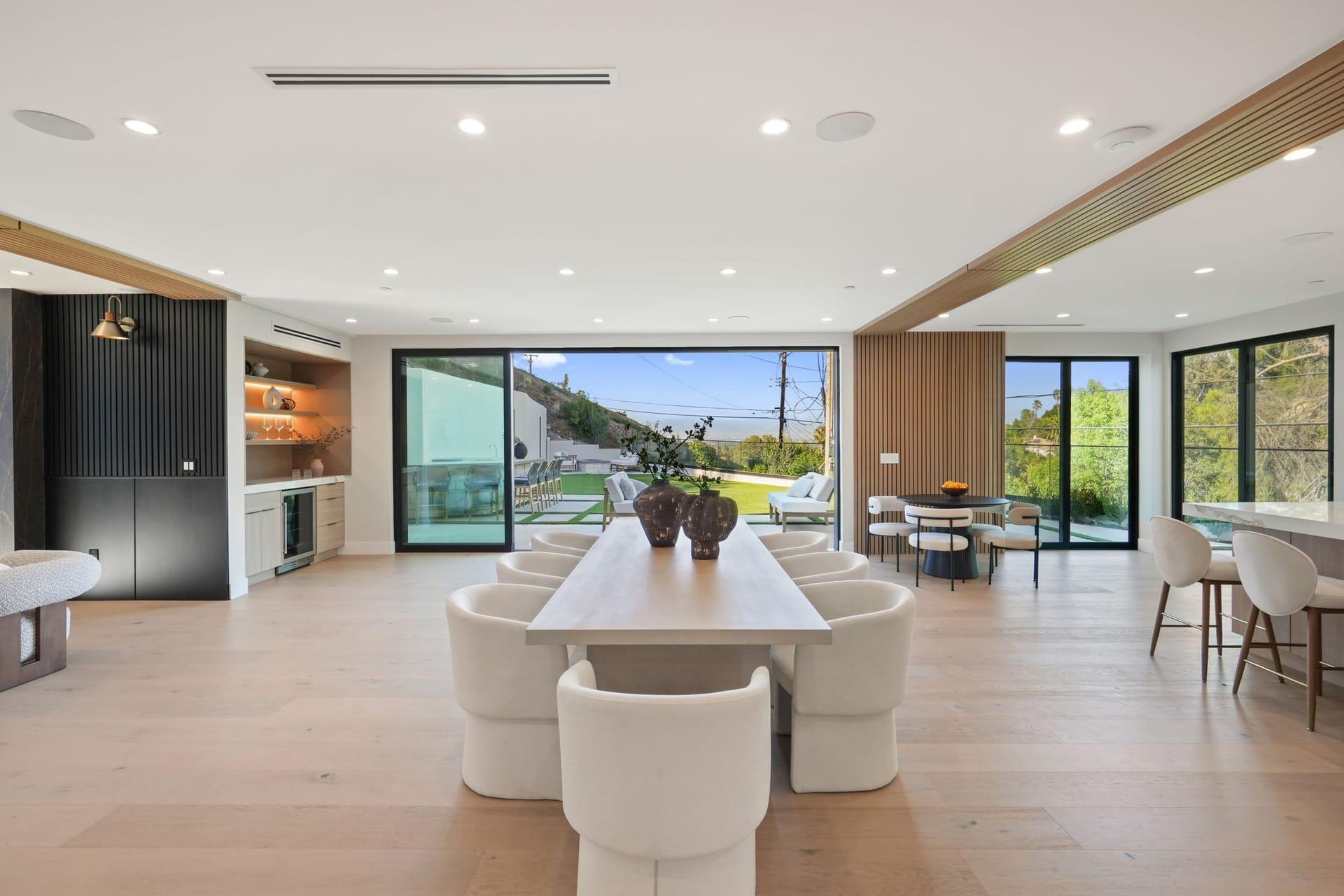 Dining area looking toward sliding glass doors that open onto the rear terrace and hillside