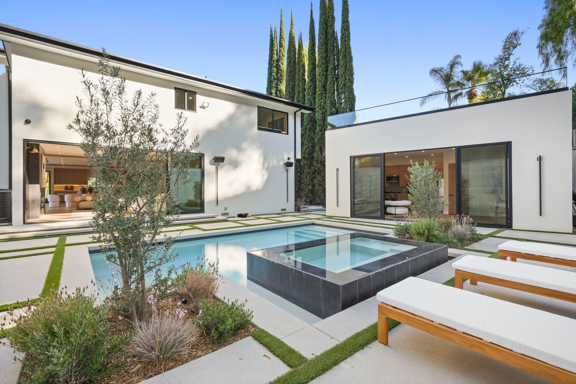 Pool and raised spa on a paved terrace at an Encino hillside residence, in daylight