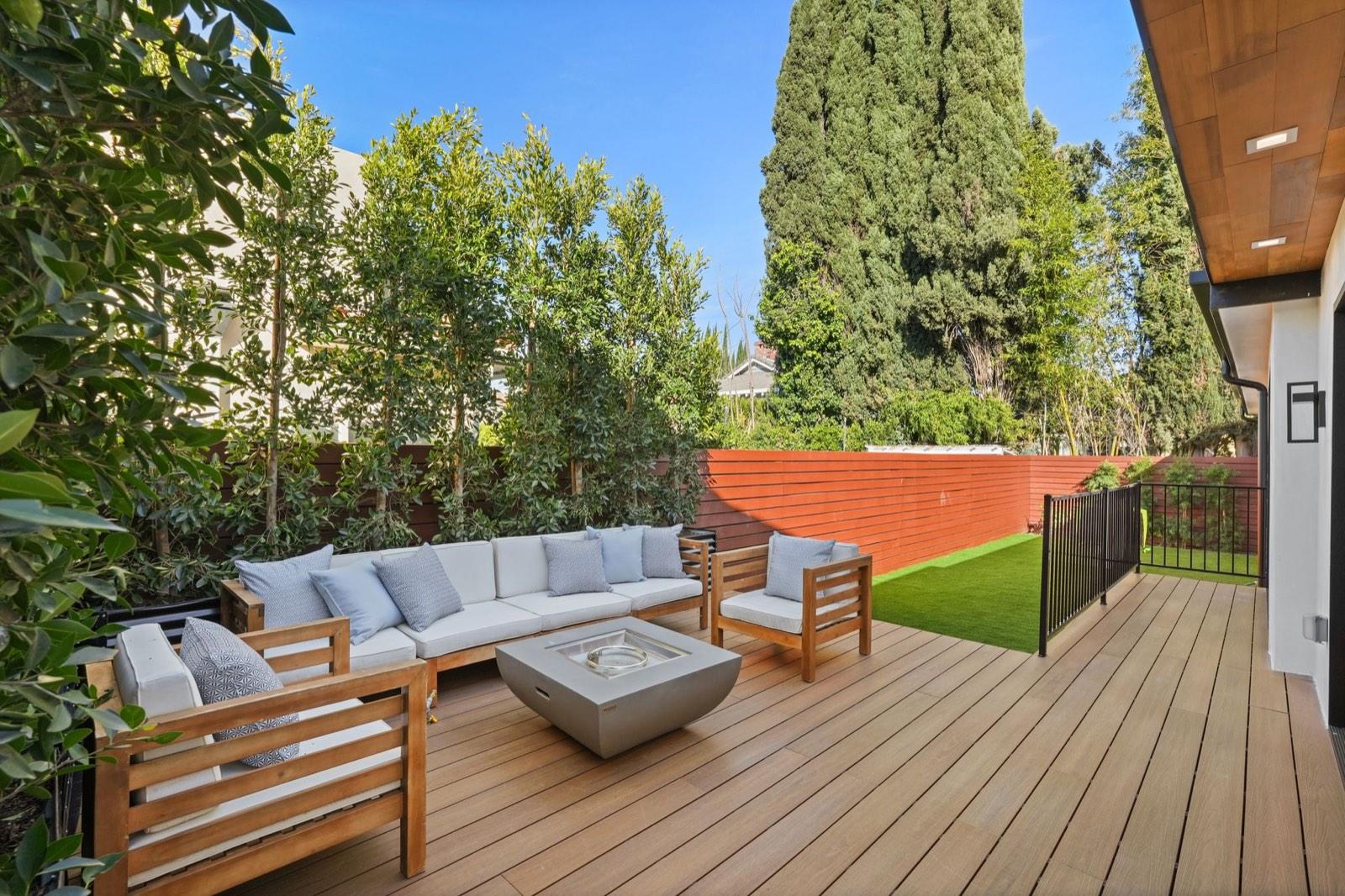Lounge seating on the rear deck beneath mature hedging